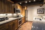 Fully equipped kitchen has stainless steel appliances and granite counters